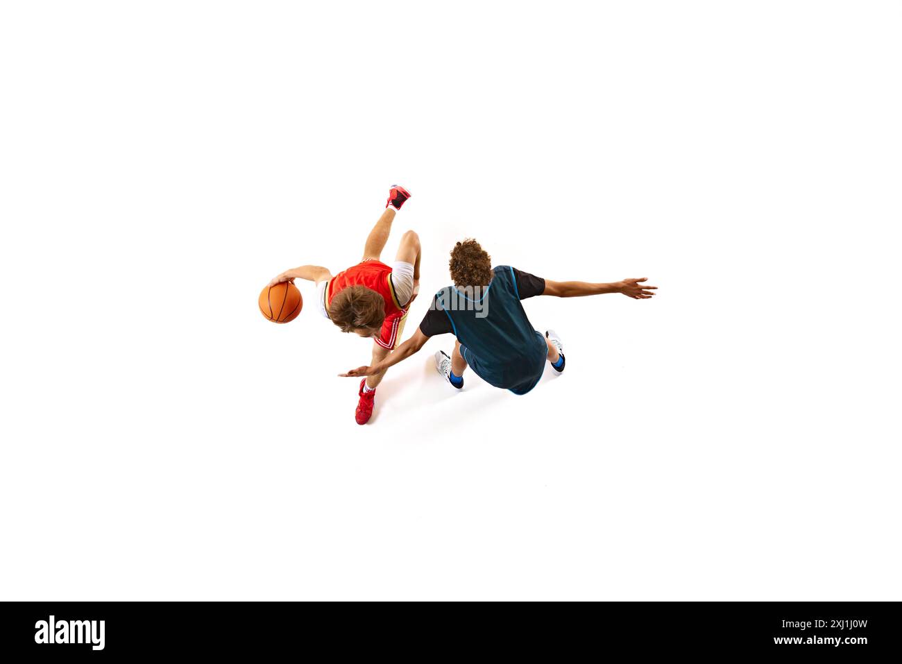 Spieler in rotem Dribbling, während der Gegner in blau versucht, ihn vor weißem Studiohintergrund vom Boden zu blockieren. Luftaufnahme. Stockfoto