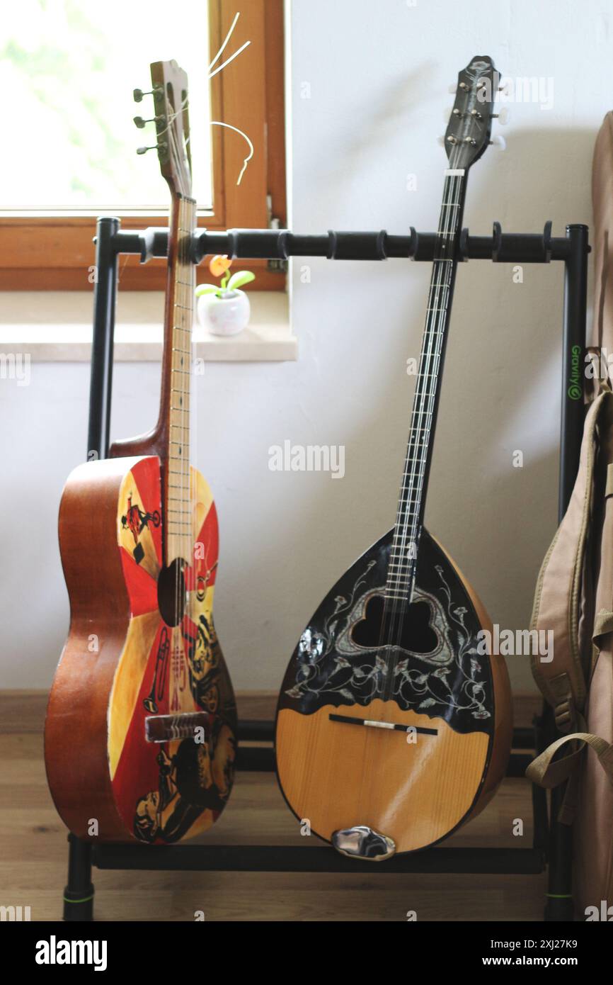 Ein fesselndes Bild mit einer Akustikgitarre und einem Bouzouki auf einem Gitarrenständer. Diese Szene zeigt die Harmonie zwischen diesen beiden Saiten Stockfoto
