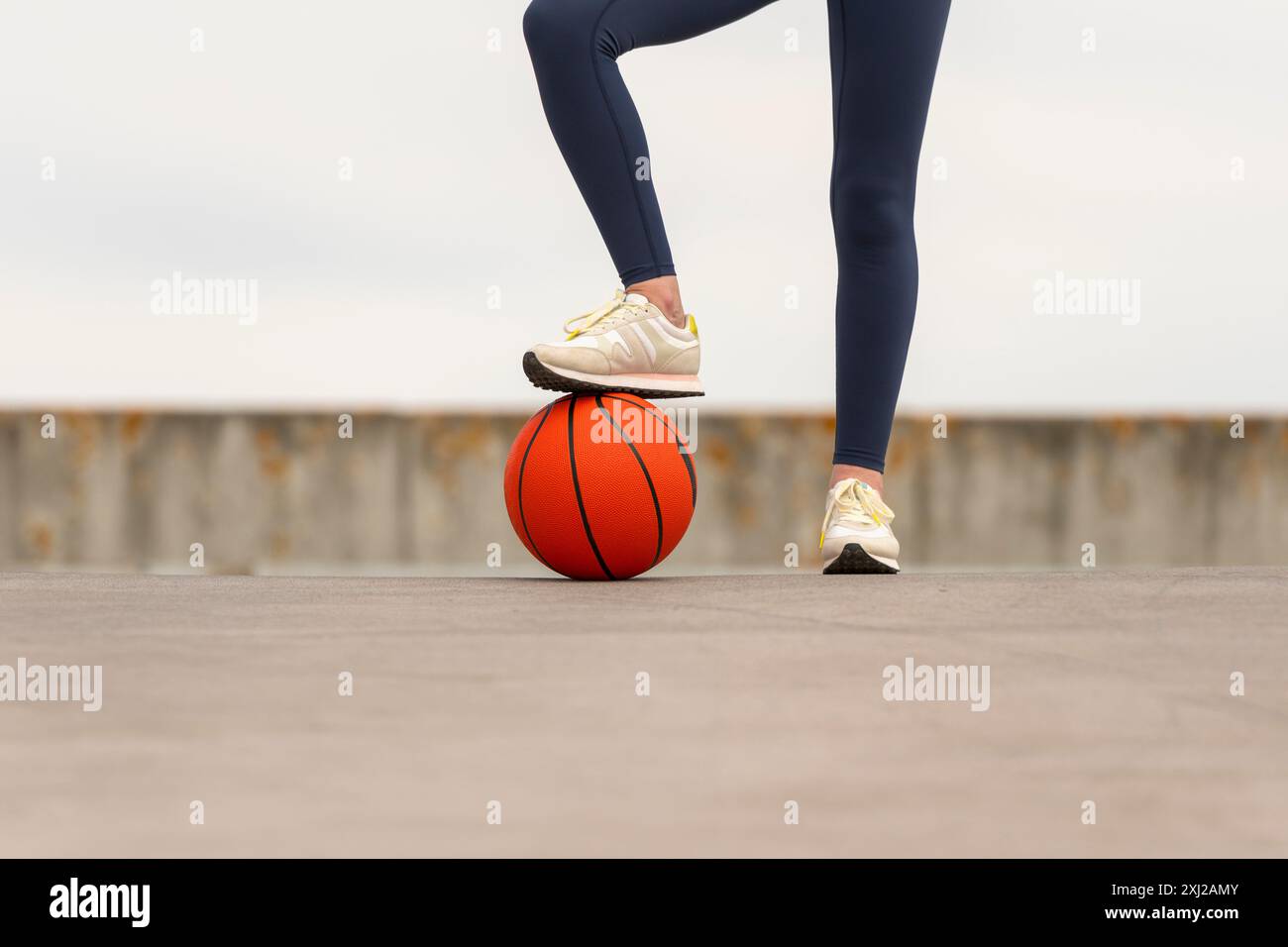 Frau mit dem Fuß auf einem Basketball, Nahaufnahme Stockfoto