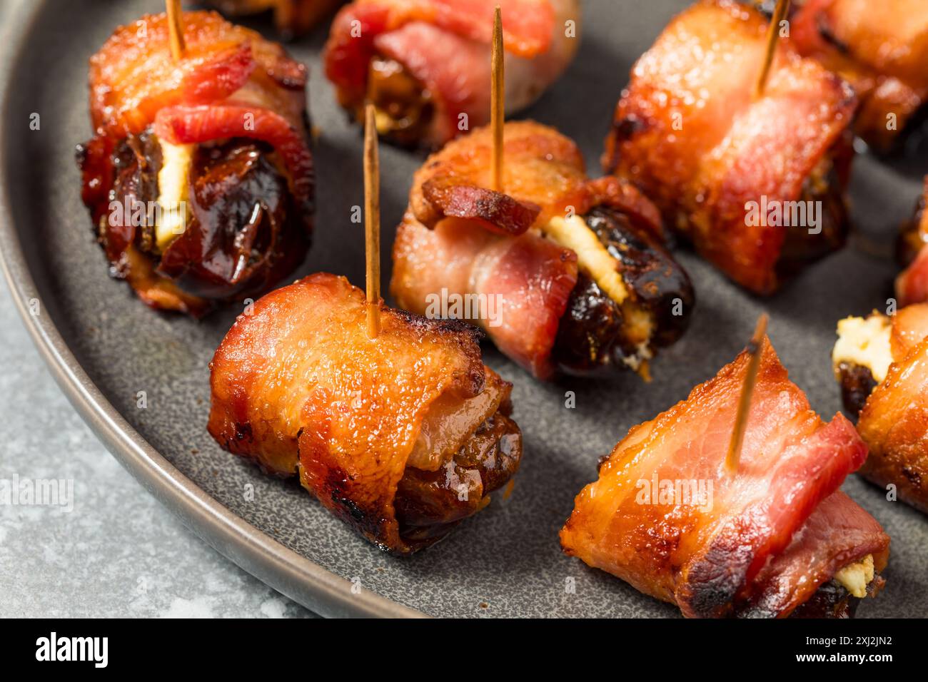 Warme, mit Speck gewickelte Datteln mit Ziegenkäse Stockfoto