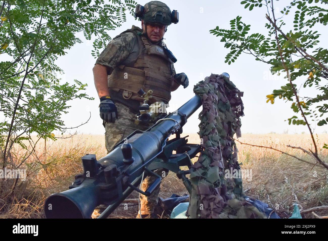 15. Juli 2024, Robotyne, Zaporischschschhia, Ukraine: Ein ukrainischer Soldat der 65. Separaten Mechanisierten Brigade bereitet sich darauf vor, eine Rakete mit SPG-9 (Panzerabwehrgranatenwerfer) auf russische Stellungen an der Frontlinie bei Robotyne zu schießen. Der unnachgiebige Druck der Ukraine, ihre Verbündeten dazu zu bewegen, Ziele innerhalb Russlands mit gespendeten Waffen zu treffen, könnte beginnen zu funktionieren, sagte Präsident Wolodymyr Zelenskij am 15. Juli 2024. Wenn diese Erlaubnis nicht erlaubt wird, wird die Ukraine ihre eigenen Waffen einsetzen, um Russland zu treffen. Viele seiner Verbündeten, angeführt von den USA, setzen den Zielen Grenzen, die sie treffen können Stockfoto