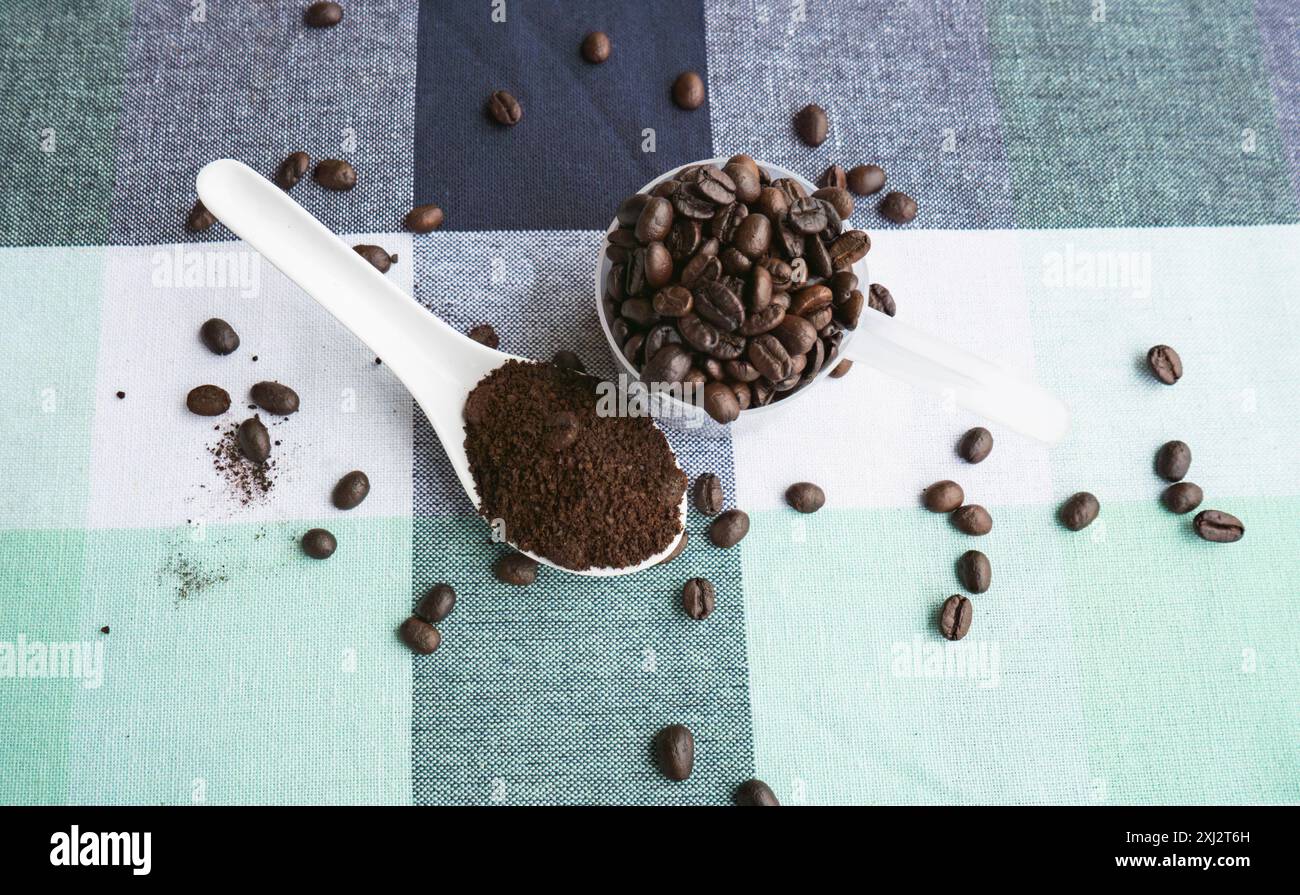Auf einem Tisch geröstete Kaffeebohnen. Ein Glas Kaffeebohnen zum Mahlen. Arabica-Bohnen in einem Café Stockfoto