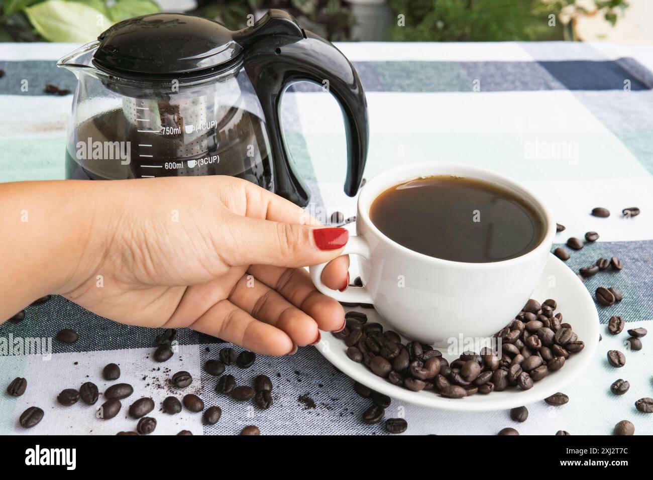 Eine Kaffeekanne mit heißem schwarzem Kaffee in einer Tasse mit Bohnen Arabica in einem schönen Café. Teekanne, Schwarzer Tee Stockfoto