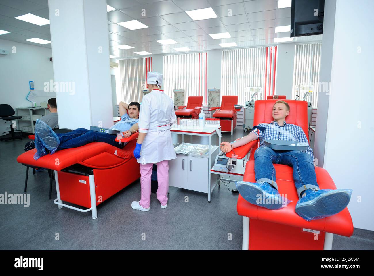 An der städtischen Bluttransfusionsstation. Krankenschwester-Apparatetrenner für Bluttransfusionen, Spender, die in Krankenhausbetten liegen. April, Stockfoto