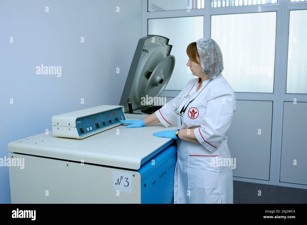 Das Pflegepersonal berührt den Schalter der Zentrifuge, um den Bluttrennungsprozess zu beginnen. Die städtische Bluttransfusionsstation. April 2019. Kiew, Großbritannien Stockfoto