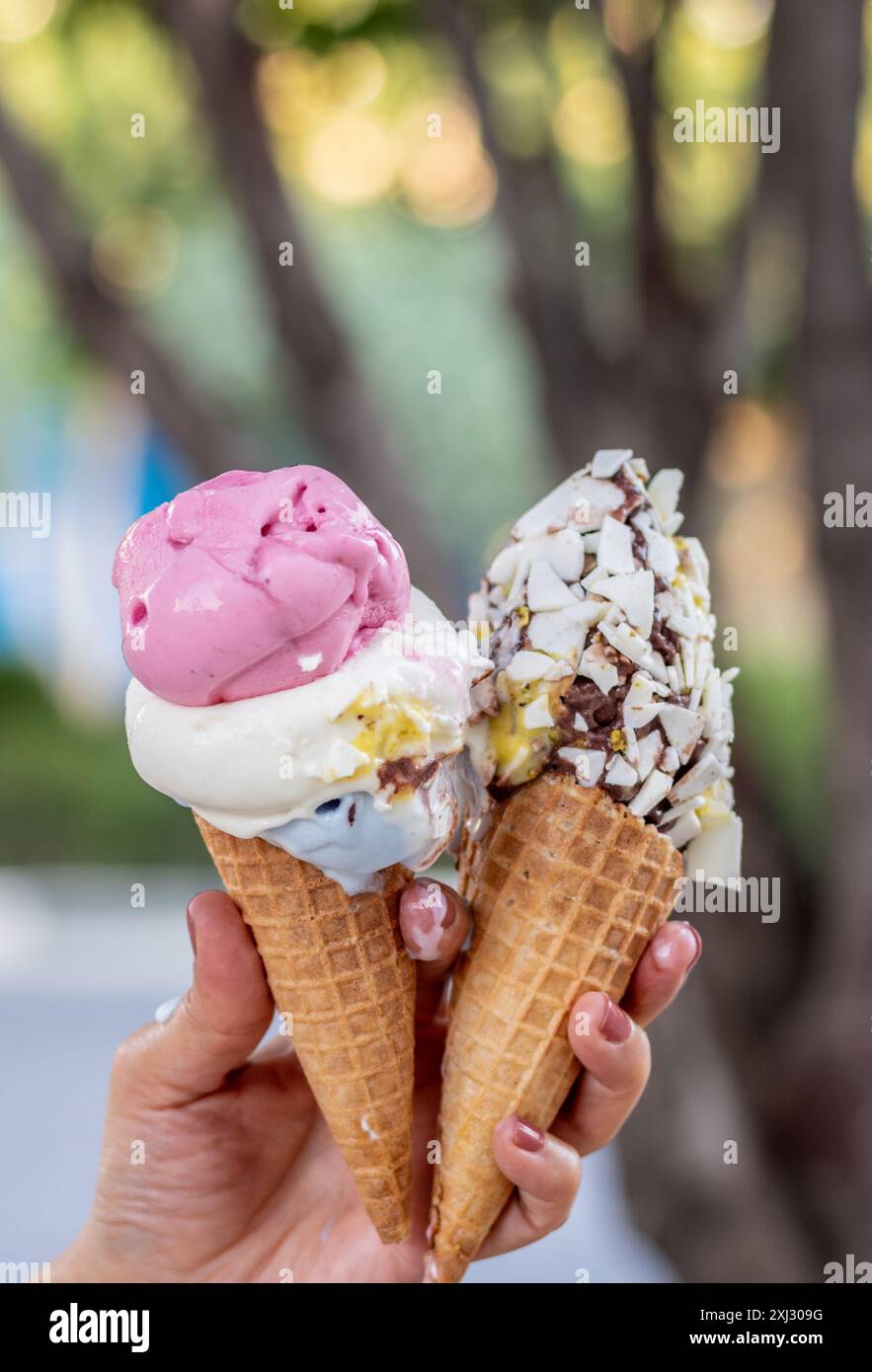 Zwei Eiskegel schmelzen in der Sommerhitze schnell. Stockfoto