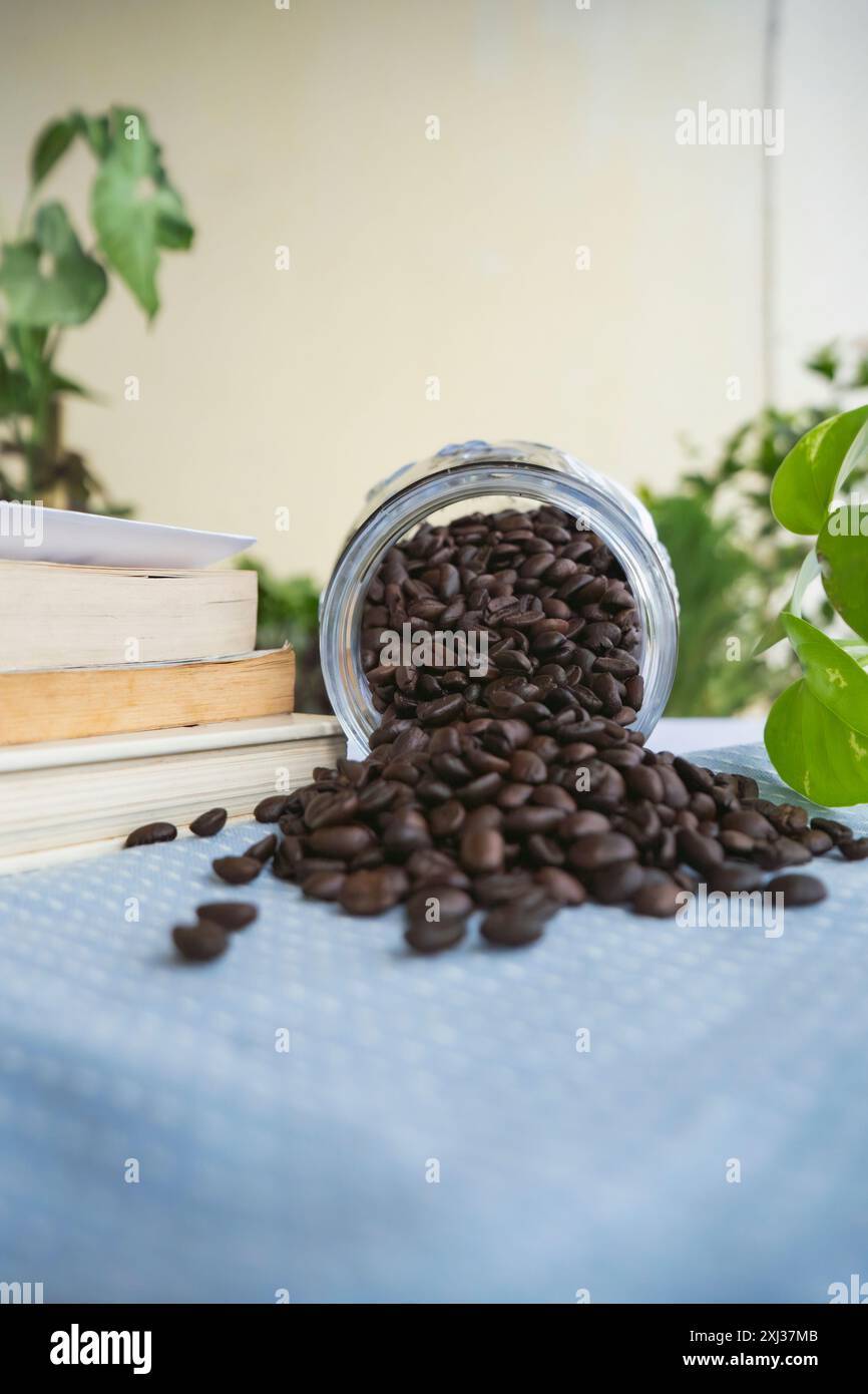Auf einem Tisch geröstete Kaffeebohnen. Ein Glas Kaffeebohnen zum Mahlen. Arabica-Bohnen in einem Café Stockfoto