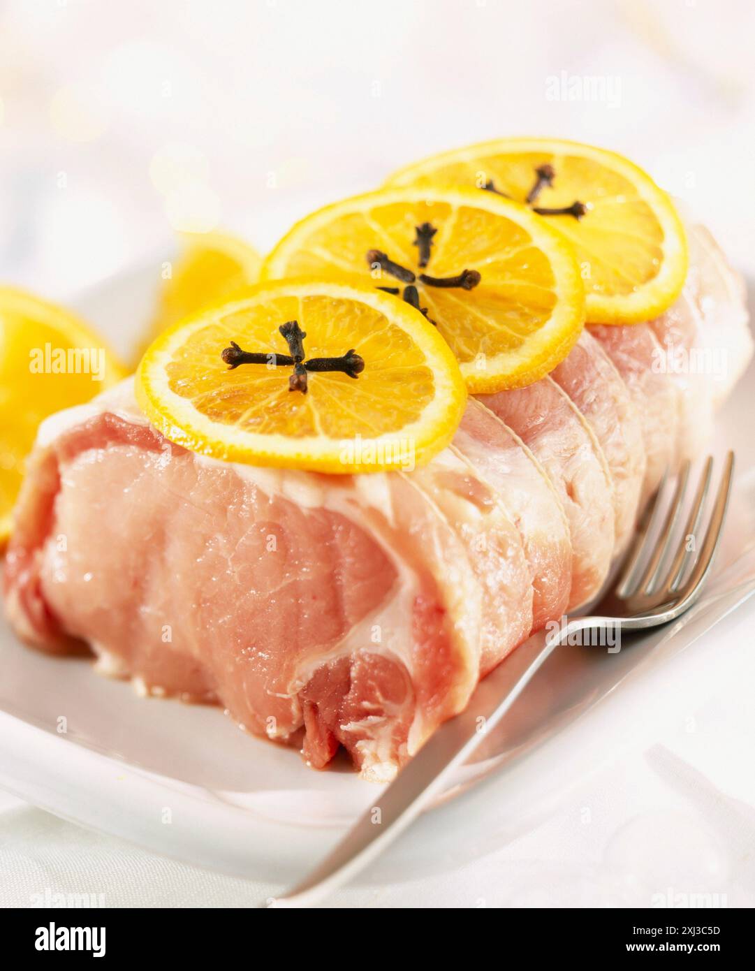 Rohes Schweinebraten mit Orangenscheiben Stockfoto