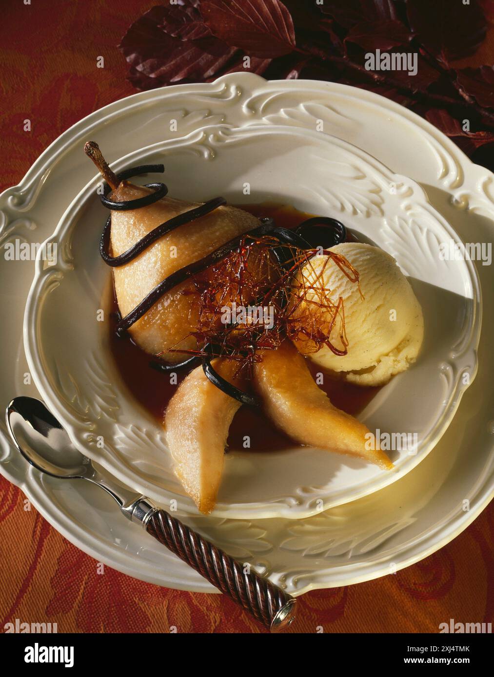 Pochierte Birne mit Karamell und Vanilleeis Stockfoto