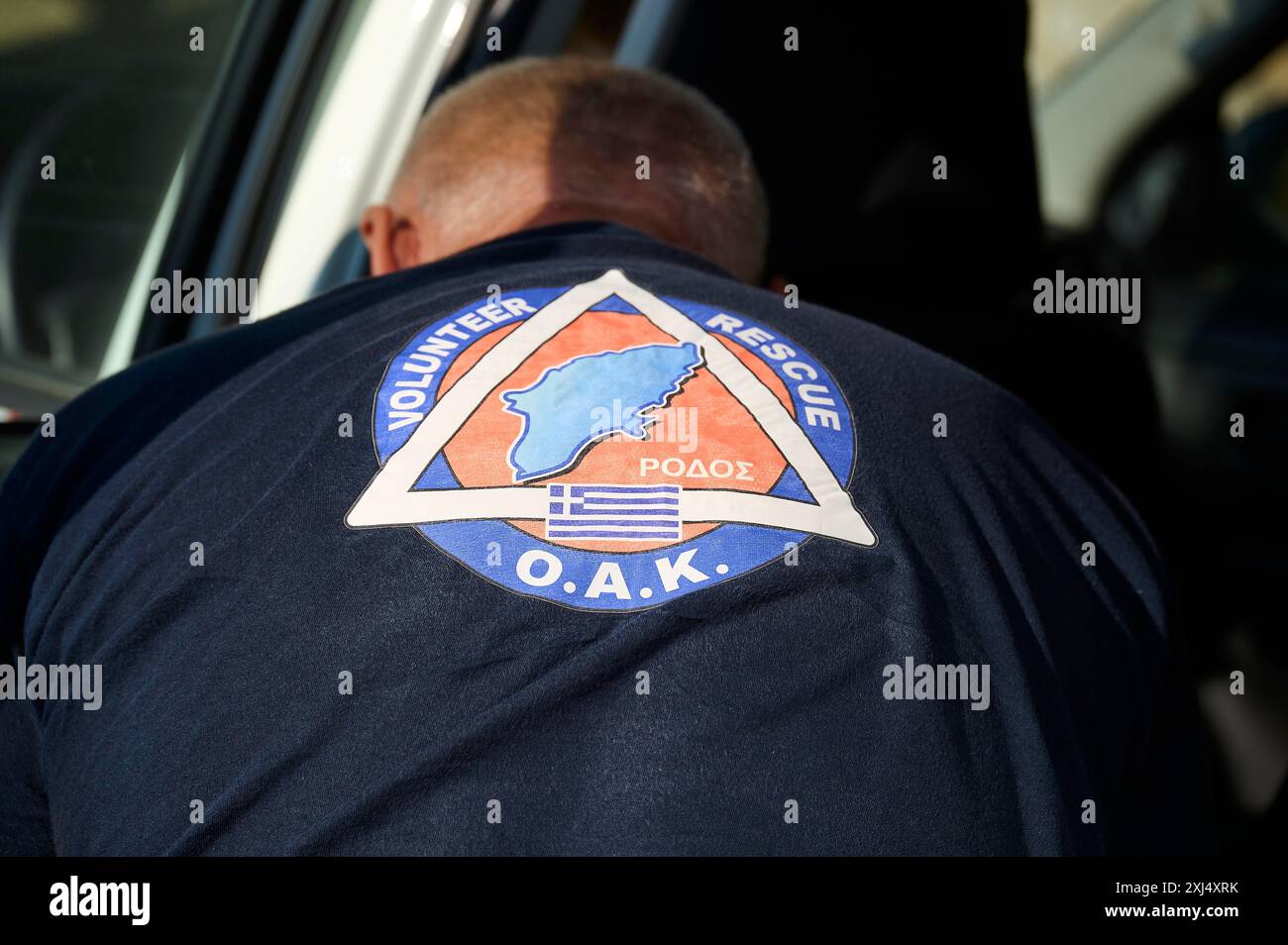 Oberkörper eines freiwilligen Helfers mit Logo und Schriftzug auf der Uniform, Waldbrände, Sommer 2023, Waldbrandschäden, Rhodos, Dodekanesisch, Griechisch Stockfoto