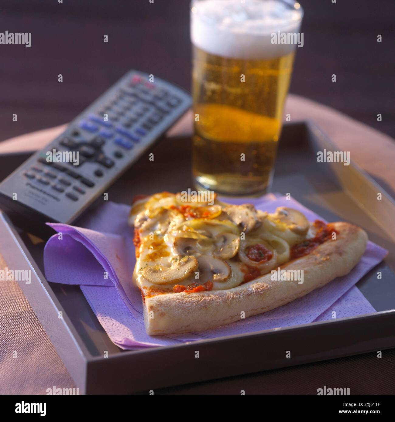 T. V-Abendessen mit einer Portion Pizza und einem Glas Bier Stockfoto