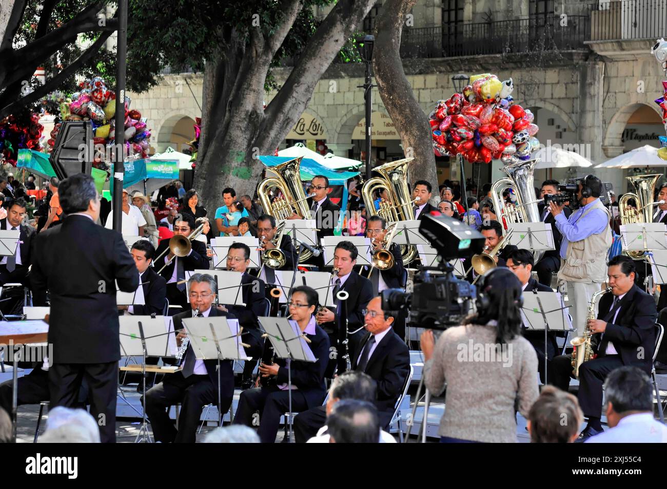 Oaxaca, Mexiko, Mittelamerika, Orchesteraufführung mit Blasinstrumenten und Dirigent, während die Menge eifrig zuschaut Stockfoto