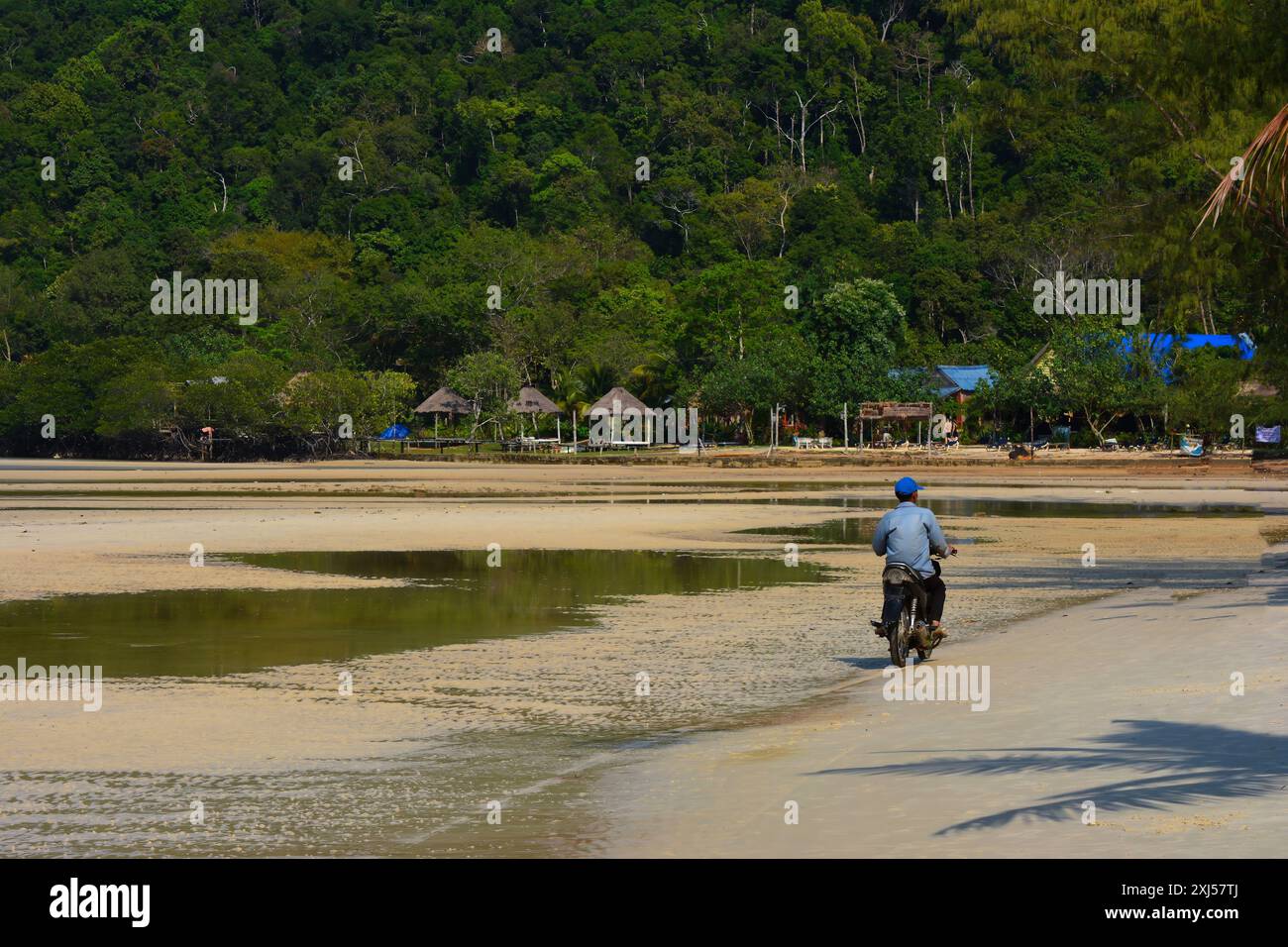 Ein Mopedfahrer an einem hübschen Strand in kambodscha, Kaoh Rong Sanloem Khnong Stockfoto