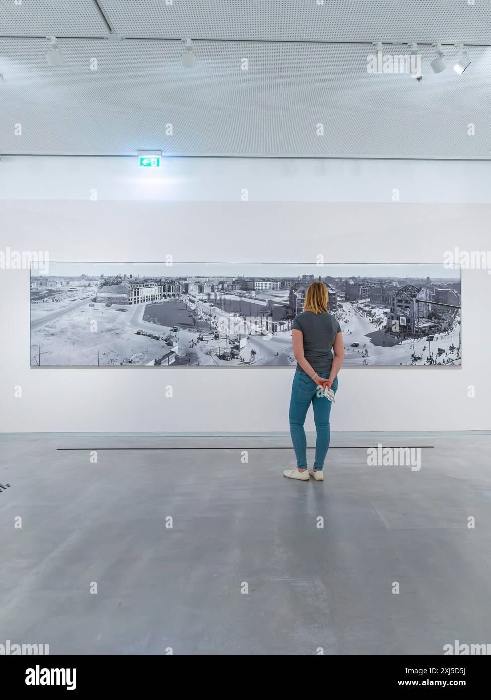 Eine Kunstgalerie, die moderne Kunstwerke ausstellt und einen Betrachter auf ein großes Gemälde blickt, Berlin, Deutschland Stockfoto