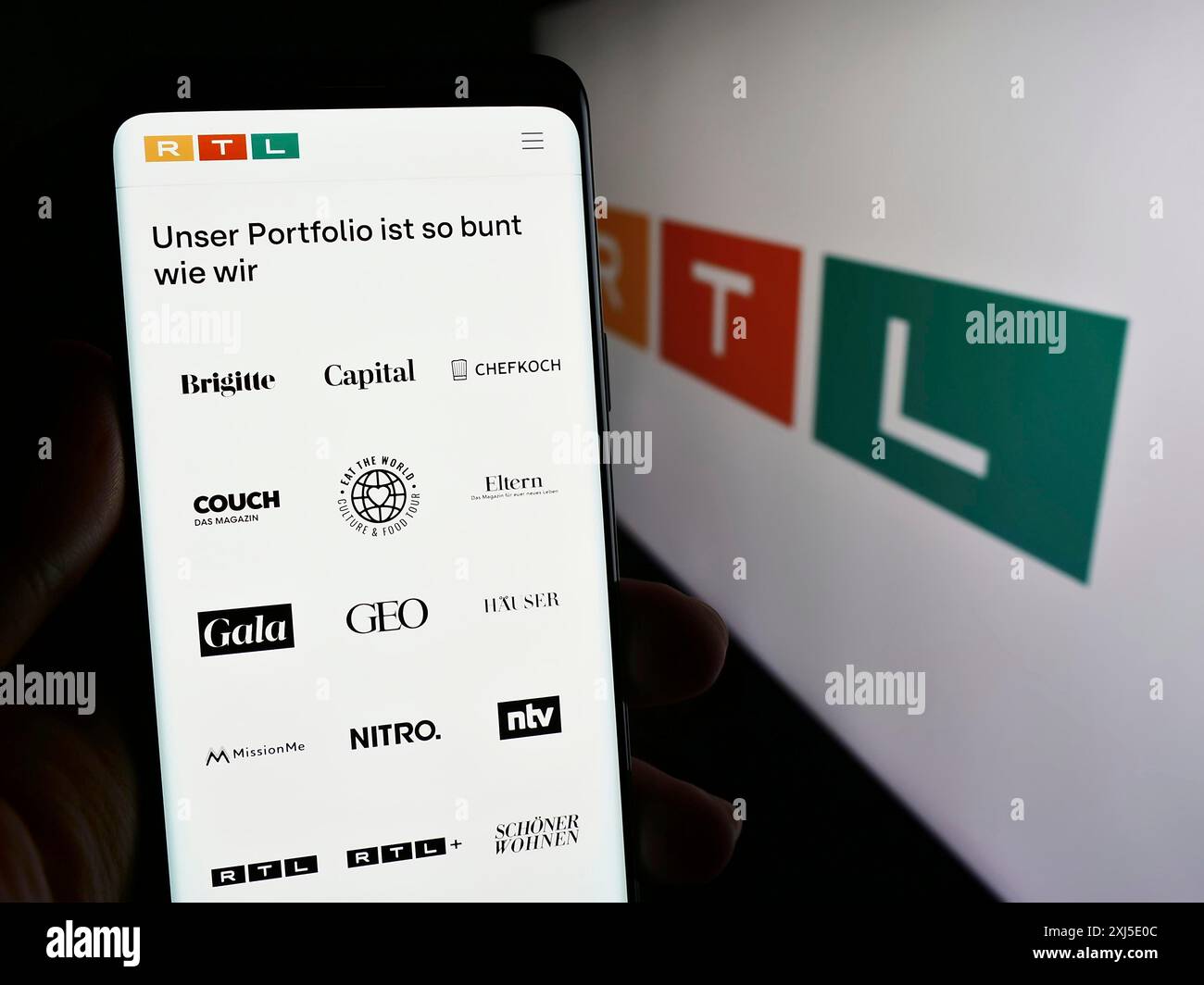Stuttgart, Deutschland, 13.02.2024: Person, die ein Mobiltelefon hält, mit Webseite des Medien- und Fernsehunternehmens RTL Group S.A. vor dem Logo. Konzentrieren Sie sich auf Stockfoto