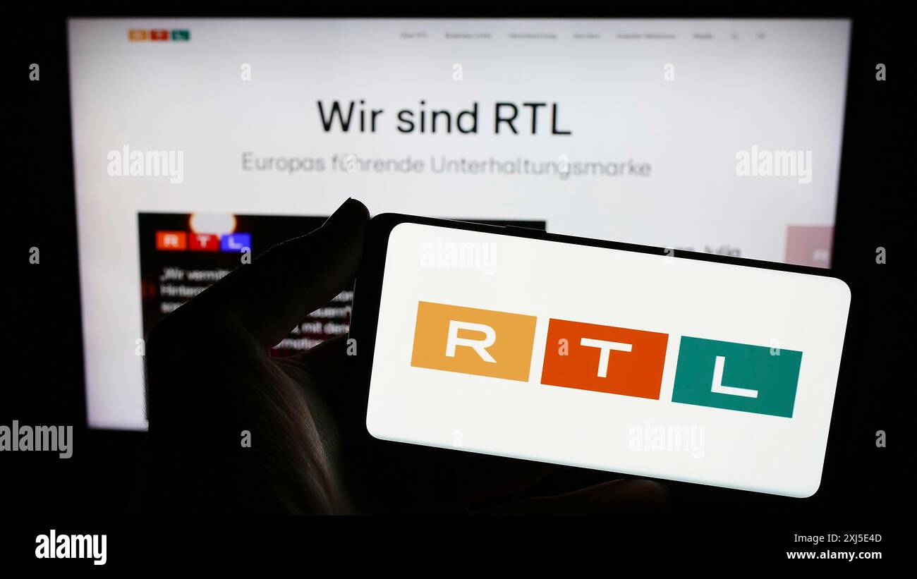Stuttgart, Deutschland, 13.02.2024: Person mit Smartphone mit Logo des Medien- und Fernsehunternehmens RTL Group S.A. vor der Website. Konzentrieren Sie sich auf Stockfoto