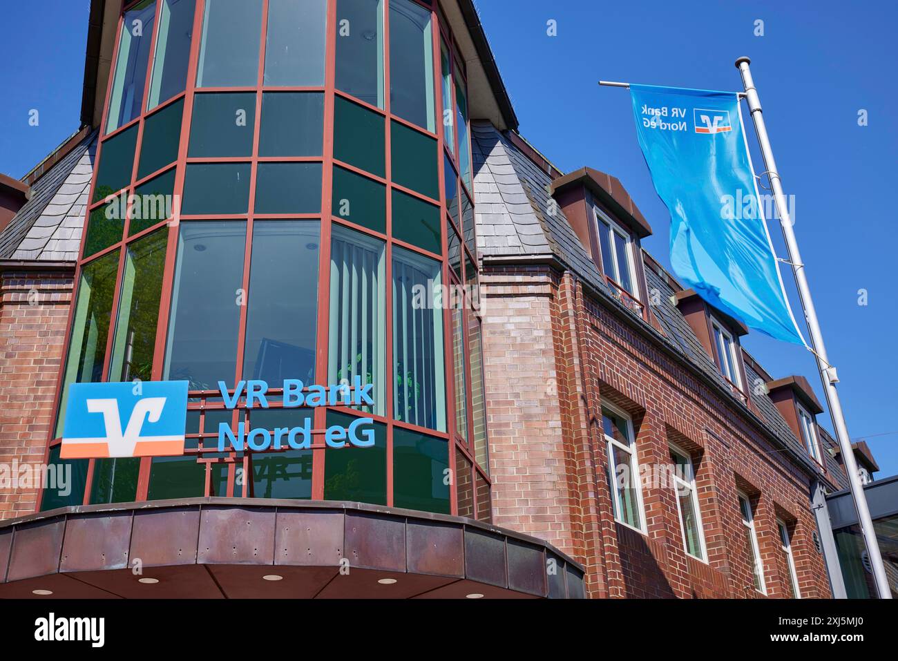Logo der Volksbank Raiffeisenbank VR Bank Nord EG mit Flaggen an der Niederlassung Niebuell, Landkreis Nordfriesland, Schleswig-Holstein, Deutschland Stockfoto