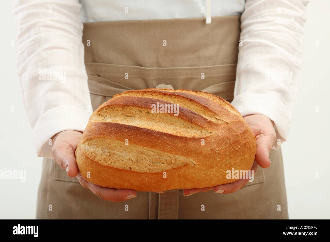 Person, die einen Brotlaib hält Stockfoto