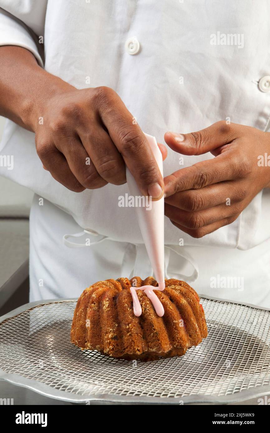 Kochen Sie einen Kuchen mit Puderzucker mit einem Paspelbeutel Stockfoto