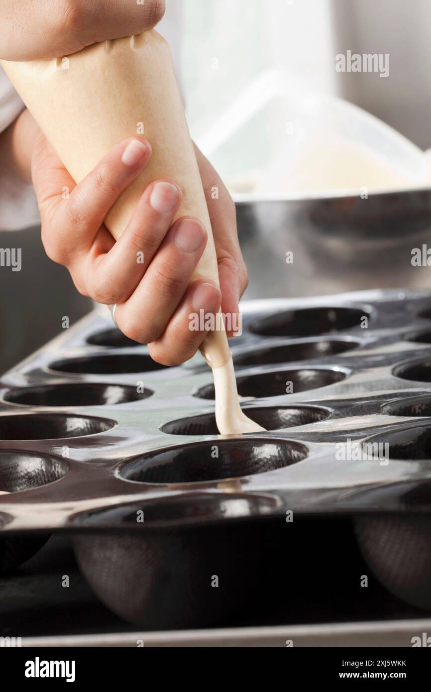 Füllen Sie die Form mit der Zubereitung mit einem Rohrleitungsbeutel Stockfoto