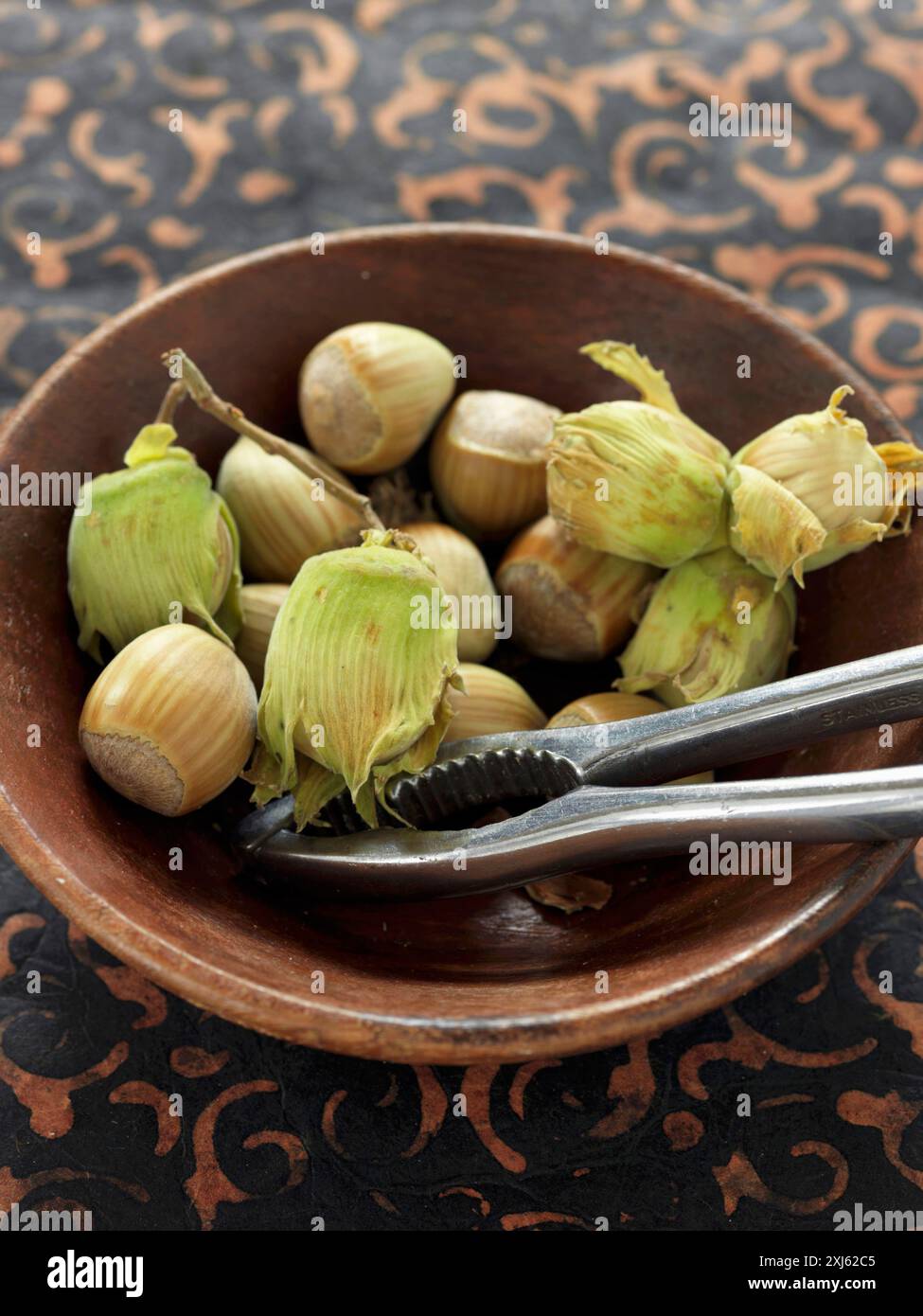 Schüssel mit frischen Haselnüssen und Nußknackern Stockfoto