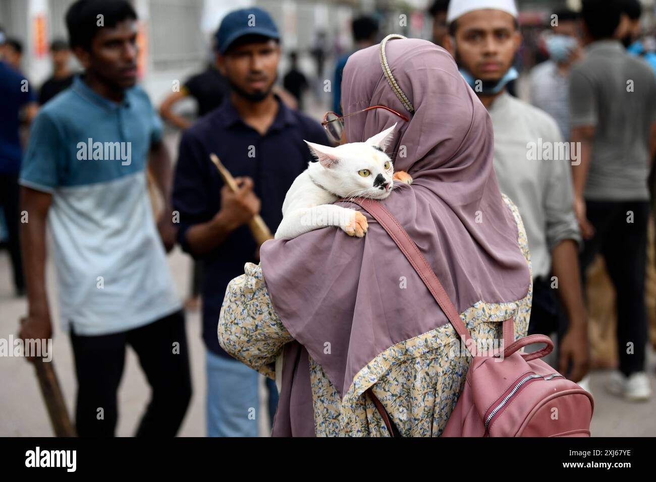 Dhaka, Bangladesch. Juli 2024. Eine Frau trägt ihre Katze zu sich nach Hause, mitten im Chaos im Chankharpool der Hauptstadt, wo es zu Konflikten zwischen der Chhatra League und den Demonstranten der Quotenreform gekommen ist. Quelle: SOPA Images Limited/Alamy Live News Stockfoto
