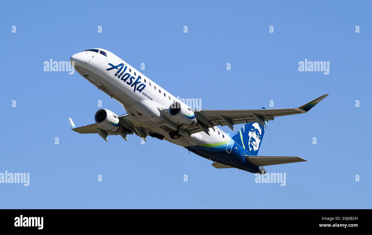 Everett, WA, USA - 11. Juli 2024; Alaska Horizon Airlines Embraer 175 N632QX fliegen isoliert gegen blauen Himmel Stockfoto