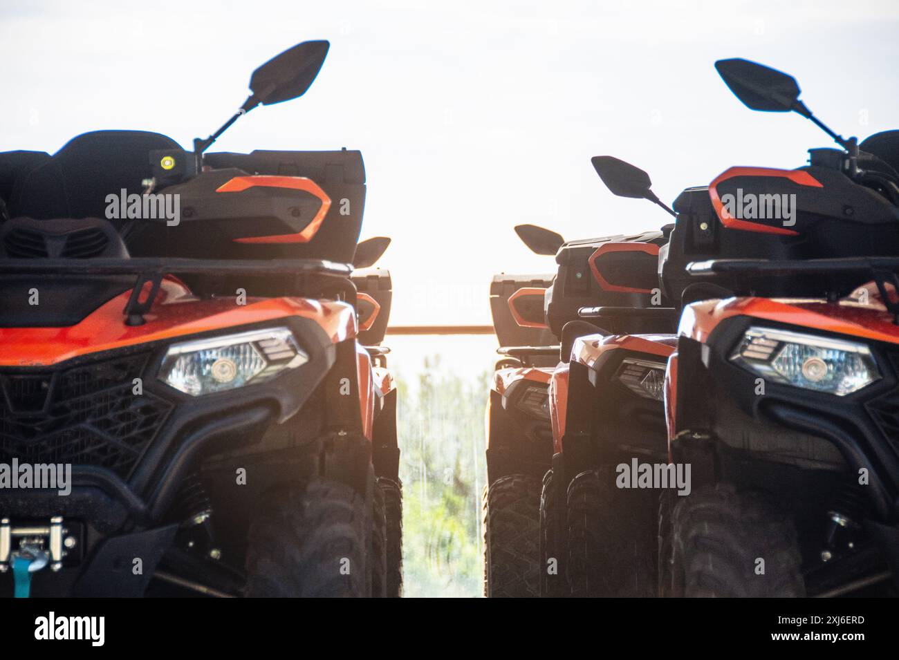 Zwei rote und schwarze Geländefahrzeuge für raue Landschaften, die bei Sonnenuntergang aufgenommen wurden und sich auf ihre detaillierte Außenausstattung und Ausrüstung konzentrieren, EMB Stockfoto