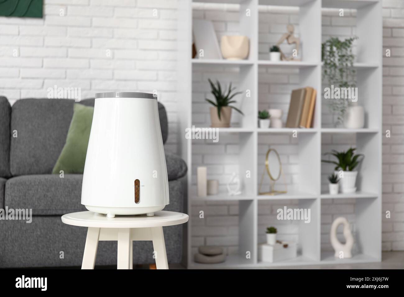 Schwarzes Sofa und moderner Luftbefeuchter auf Couchtisch im Wohnzimmer Stockfoto