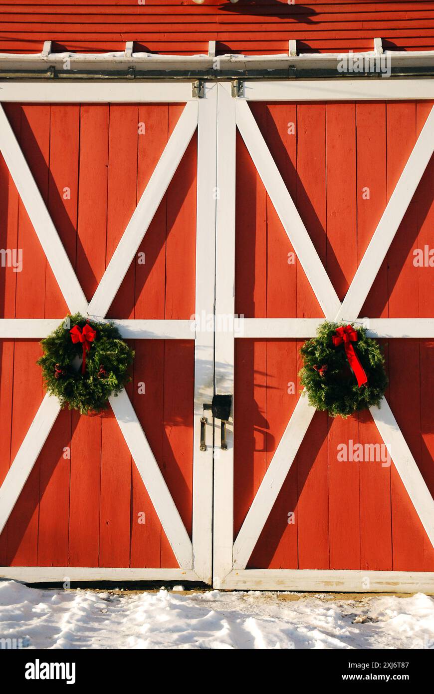 Weihnachtskränze hängen an einer Scheunentür Stockfoto