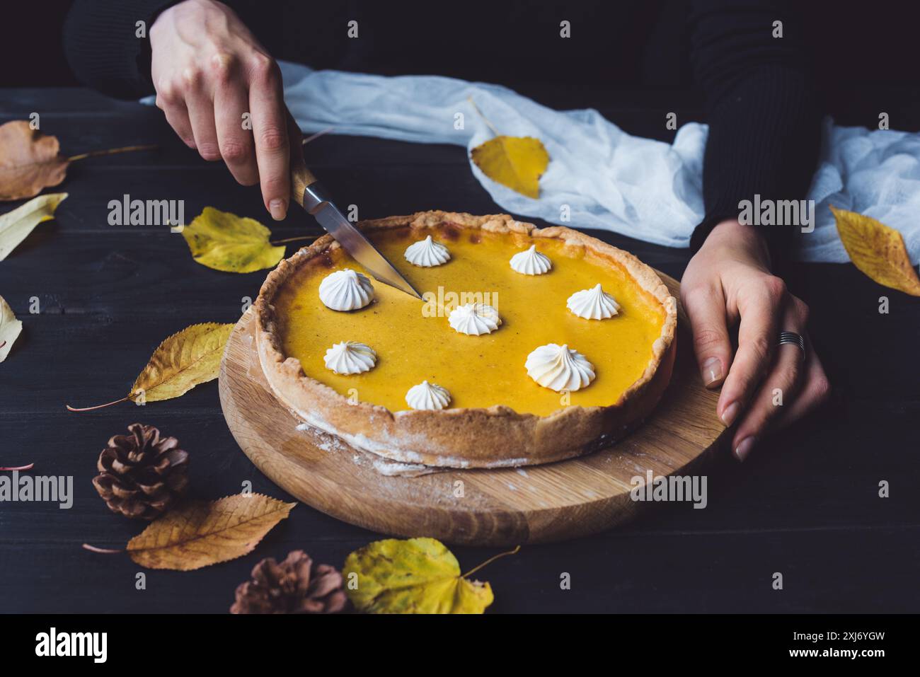Weibliche Hände schneiden Kürbiskuchen Stockfoto