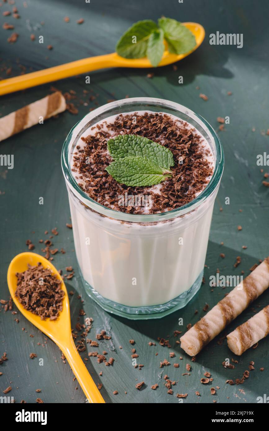 Closeup Schuß von milchshake mit Schokolade rasieren und Minze, Löffel und süßen Strohhalme auf Tisch Stockfoto