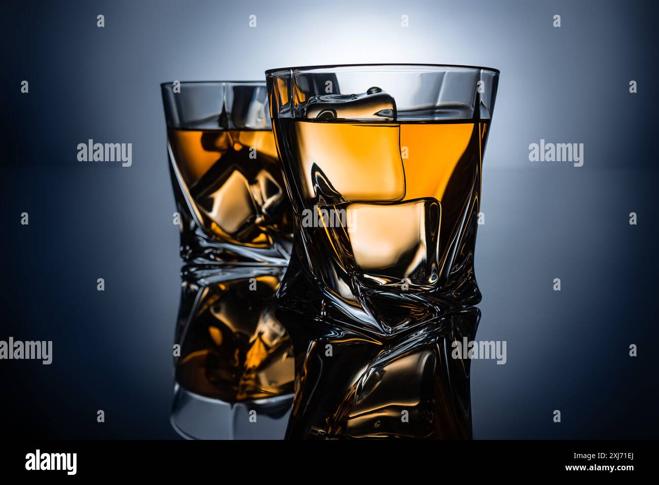 Zwei Gläser Whisky mit Eiswürfel, auf dunkelgrauem Hintergrund Stockfoto