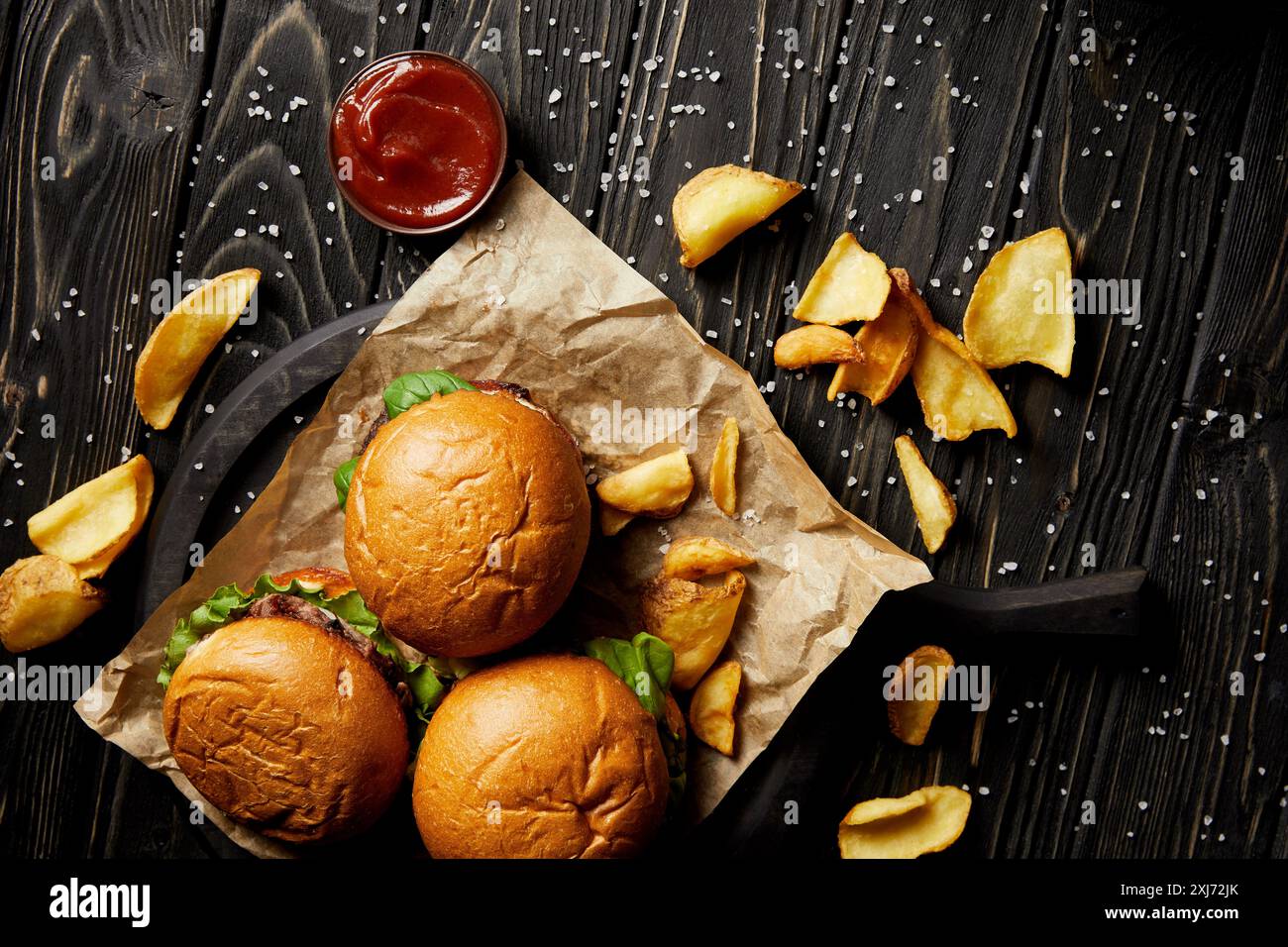 Blick von oben auf die Hamburger und Pommes Frites mit Ketchup auf hölzernen Tisch Stockfoto