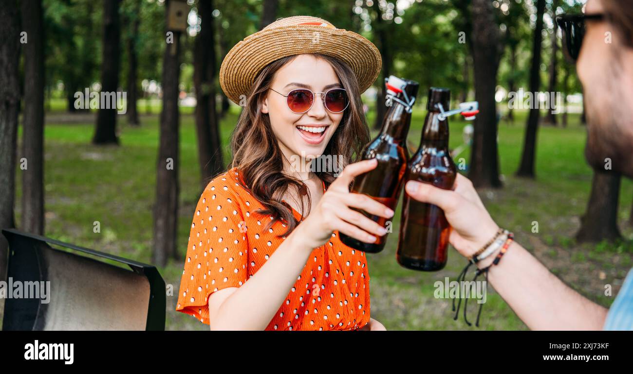 Teilweise mit Blick auf die paar klirrenden Flaschen Bier während der Grill im Park Stockfoto