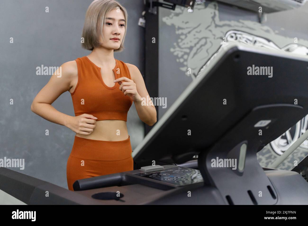 Junge schöne Frau, die auf dem Laufband läuft, während sie morgens in einem Fitnessstudio trainieren Stockfoto