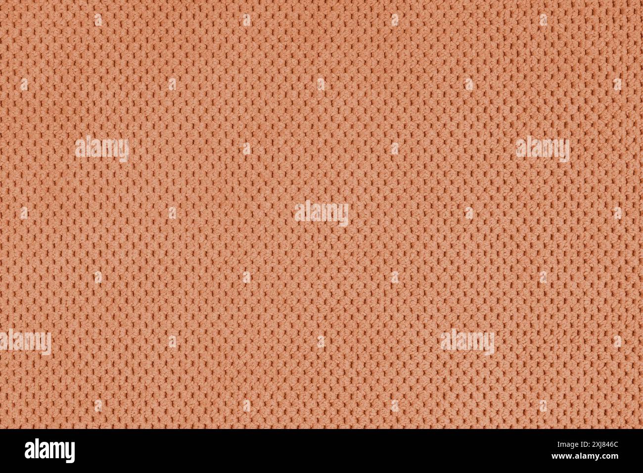 Einfarbiges, orangefarbenes Veloursmaterial, flauschiges Jacquard mit gemusterter Webstruktur im Hintergrund. Nahaufnahme, Textiloberfläche aus Makrogewebe. Hintergrundbild, Backdr Stockfoto