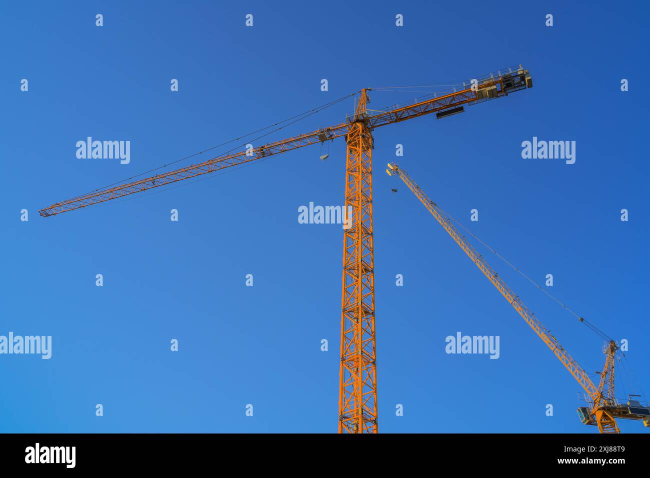 Turmkräne auf der Baustelle vor blauem Himmel Stockfoto
