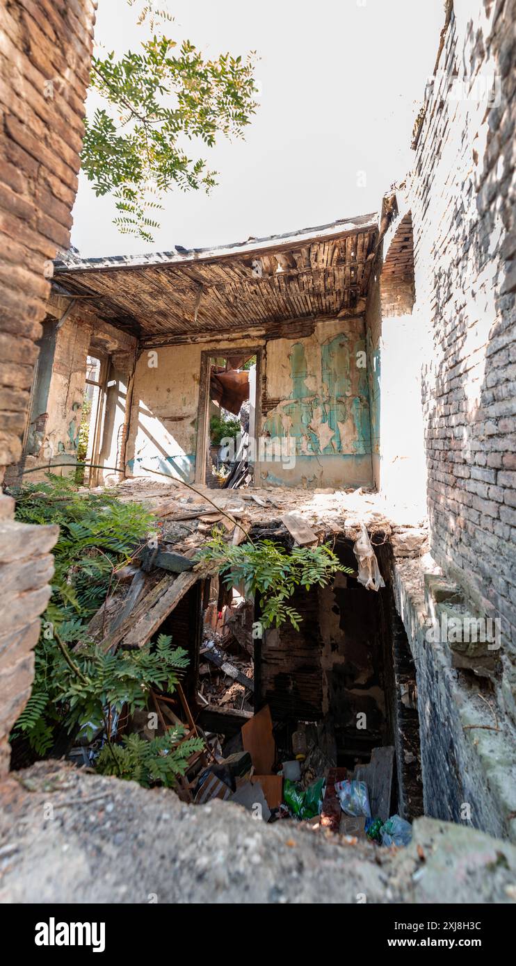 Tiflis, Georgien - 24. JUNI 2024: Verlassenes und teilweise zerfallenes traditionelles georgianisches Haus in der Altstadt von Tiflis, Georgien. Stockfoto