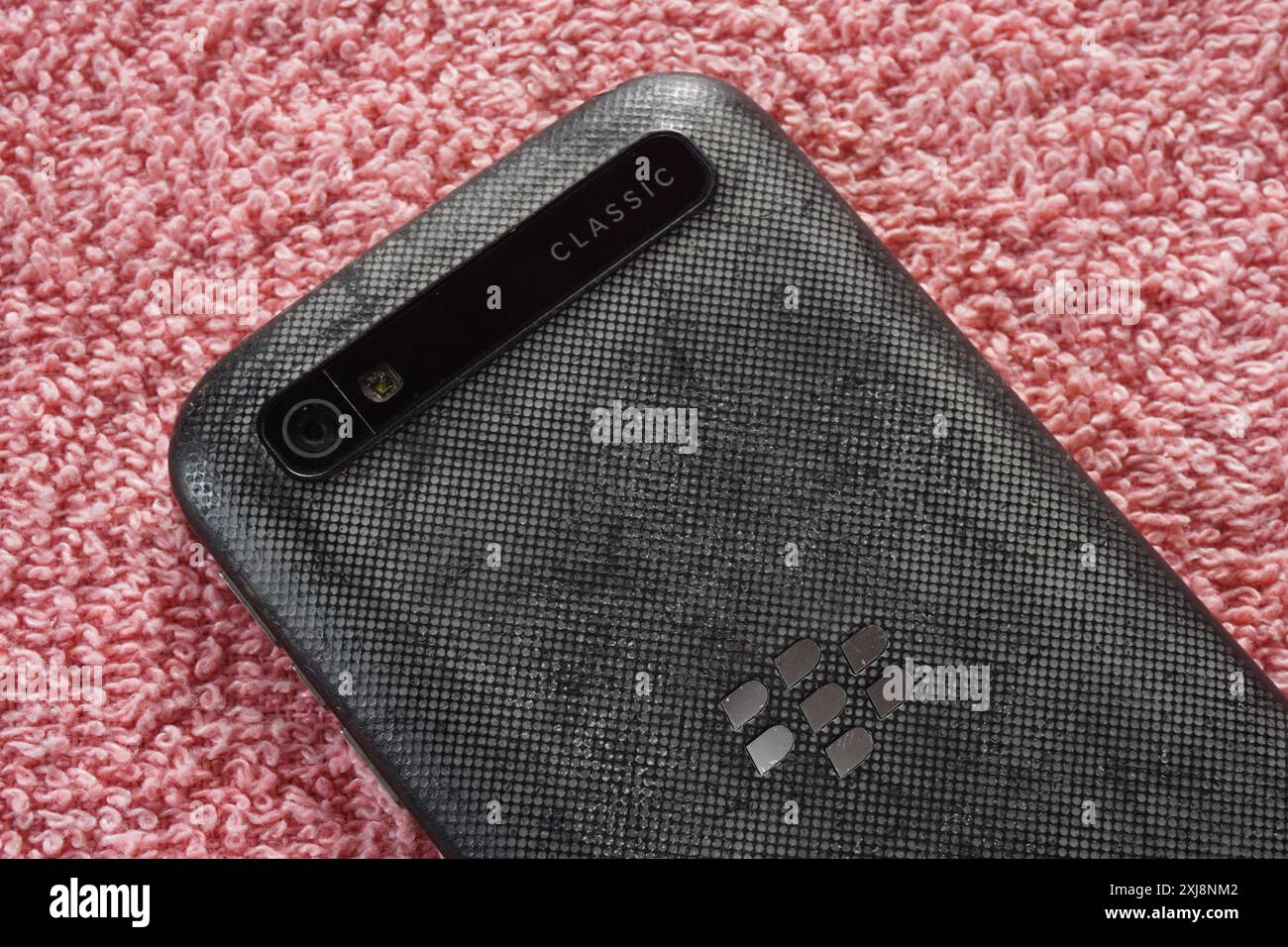 Terengganu, Malaysia - 2. August 2024 : Nahaufnahme des klassischen blackberry-Handys q20 auf rotem Hintergrund. BlackBerry-Logo. Stockfoto