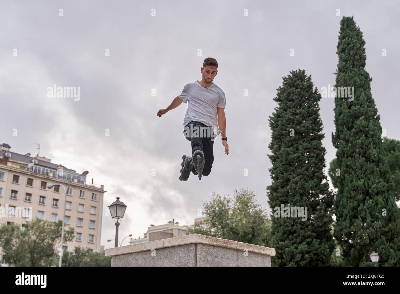 Rollschuhläufer auf den extremen Rollschuhen mit akrobatischem Sprung bei bewölktem Himmel - alternatives Lifestyle-Konzept Stockfoto