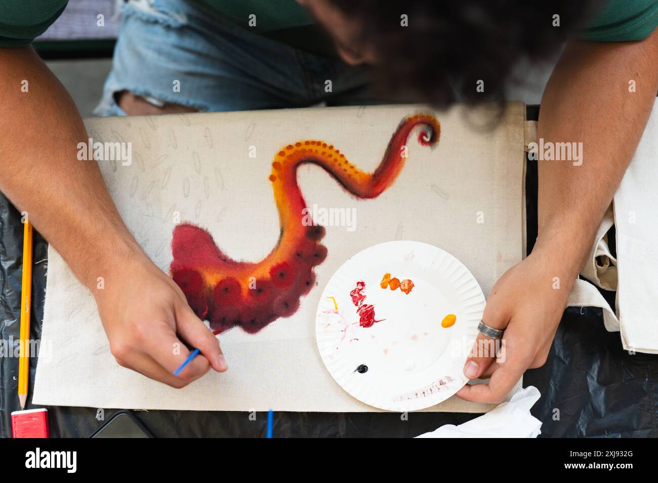 Kunststudent, der ein Bild der Tentakel eines Oktopus malt Stockfoto