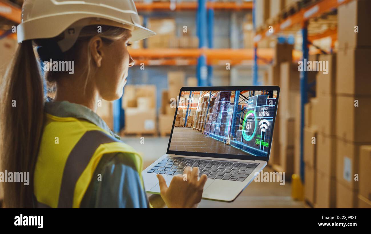 Futuristic Technology Warehouse: Weibliche Mitarbeiterin, Die Inventar Macht, Mit Dem Augmented Reality-Programm Auf Laptop-Computern. Frau analysiert digitalisierte Produkte Infografiken zur Bereitstellung im Vertriebszentrum. Stockfoto