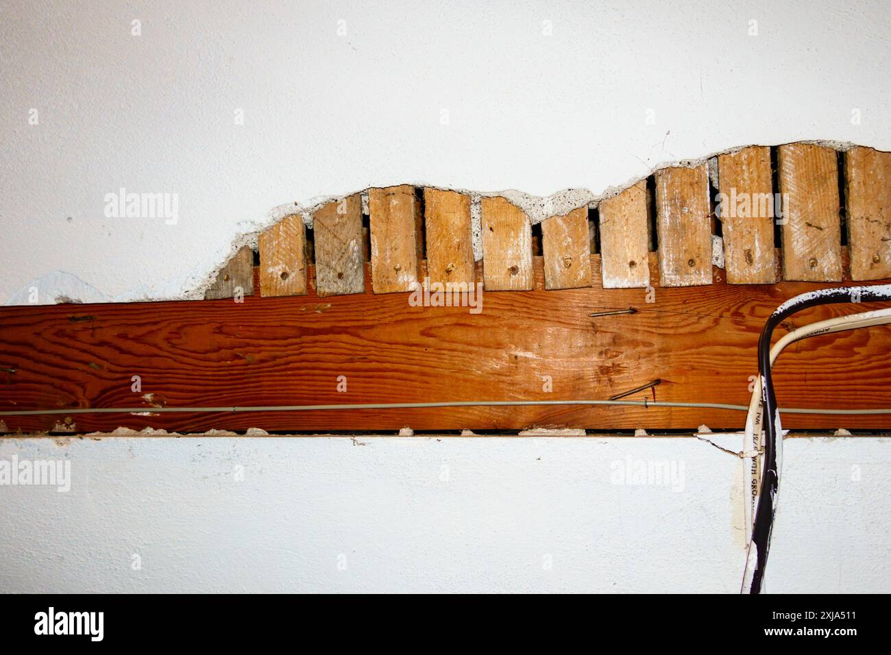 Freiliegende elektrische Leitungen in einem Untergeschoss des Hauses. Stockfoto