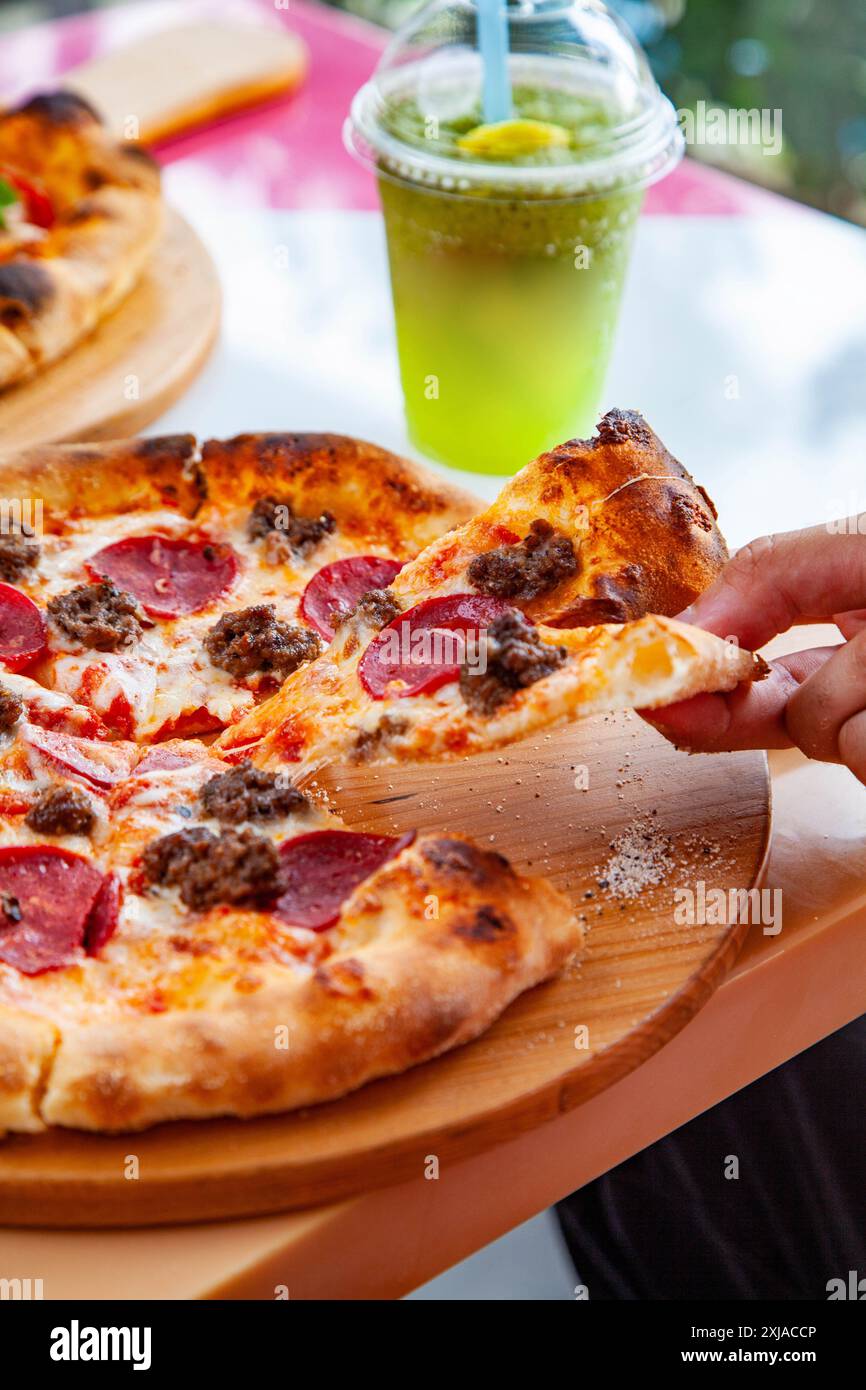 Lifestyle-Essen mit italienischer Pizza neapel, von Hand mit frischen Zutaten und kühleren Getränken. Stockfoto