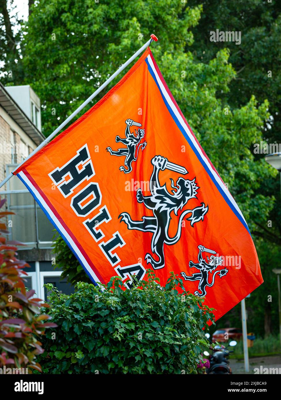 Orangefarbene niederländische Fußballfahne mit einem Löwen und dem Namen Holland. Fußballfans lassen diese besondere niederländische Flagge bei einem großen Fußballevent fliegen. Stockfoto