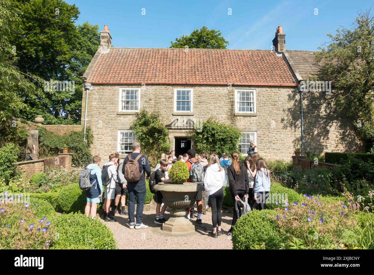 Eine Gruppe von Schulkindern vor dem Pockerley Manor House im Beamish Museum im Nordosten Englands, Großbritannien Stockfoto