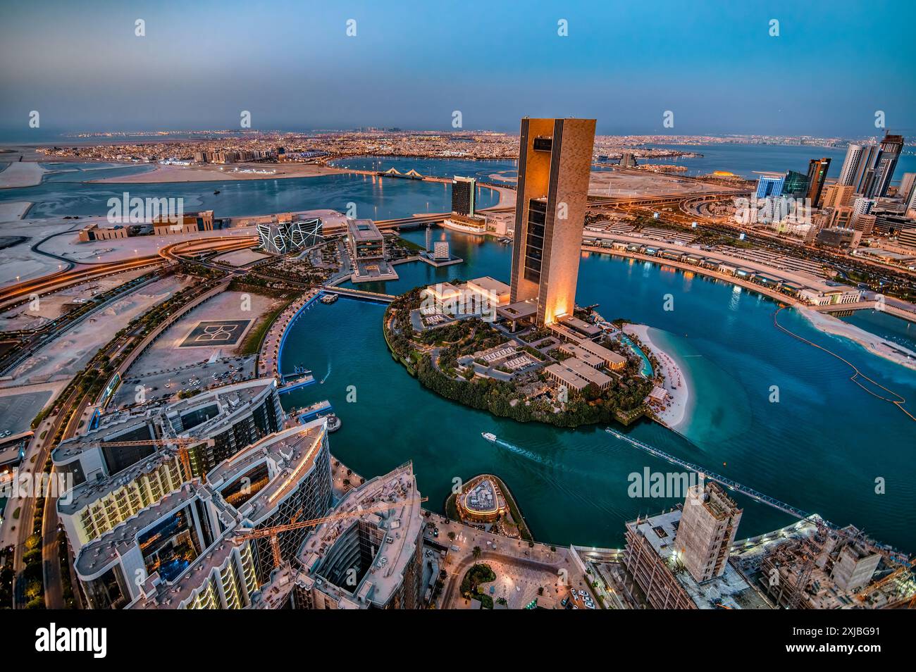 Manama, Bahrain bei Sonnenuntergang mit Megacity-Skyline, Wolkenkratzern, moderner Architektur, leuchtenden Lichtern der Stadt und urbanem Golf-Flair Stockfoto