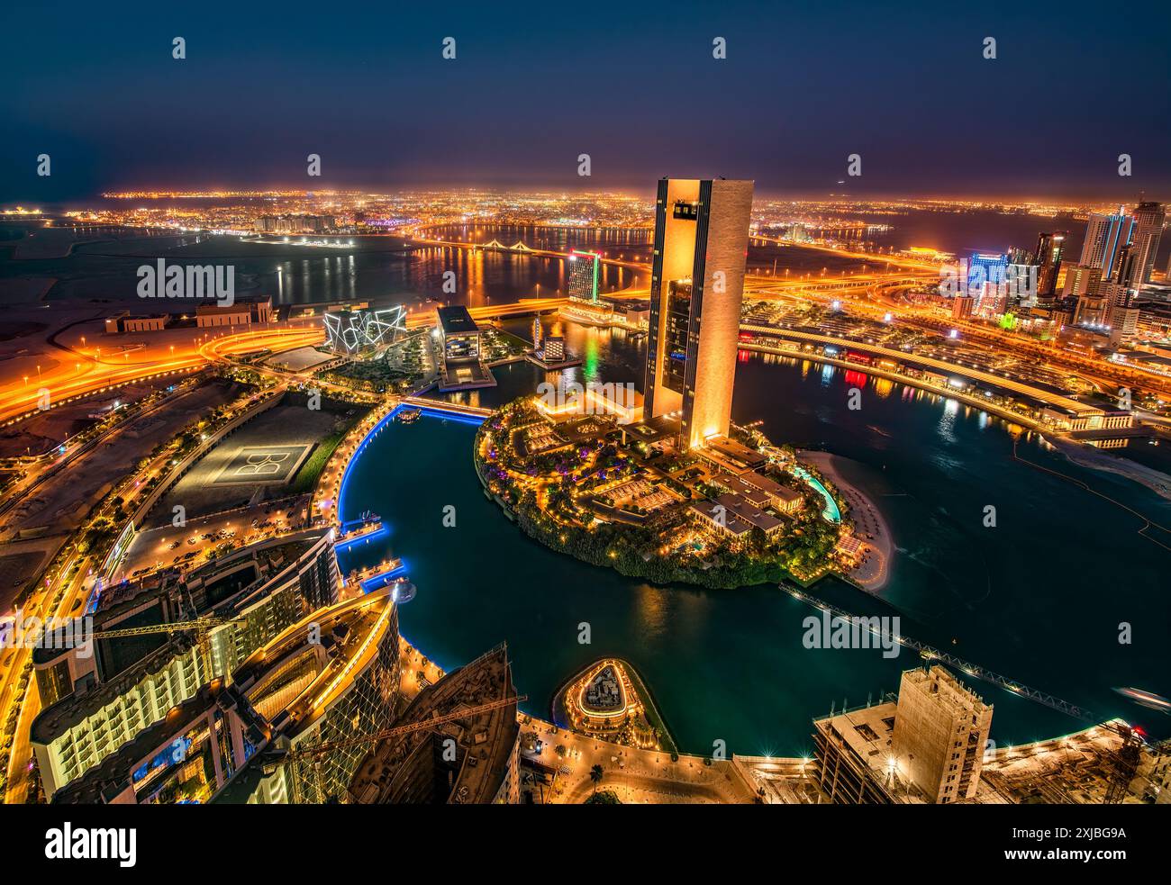 Manama, Bahrain bei Sonnenuntergang mit Megacity-Skyline, Wolkenkratzern, moderner Architektur, leuchtenden Lichtern der Stadt und urbanem Golf-Flair Stockfoto