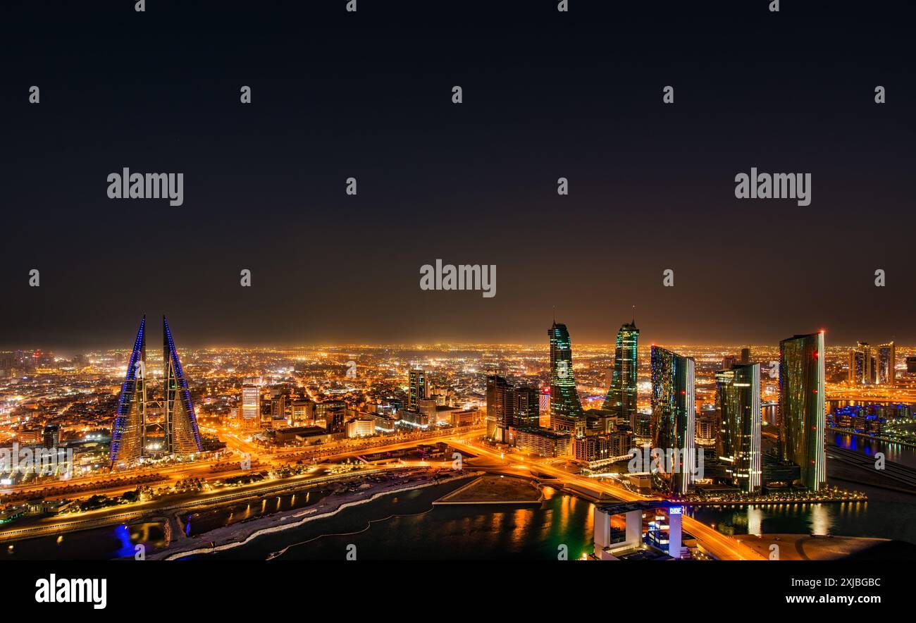 Manama, Bahrain bei Sonnenuntergang mit Megacity-Skyline, Wolkenkratzern, moderner Architektur, leuchtenden Lichtern der Stadt und urbanem Golf-Flair Stockfoto